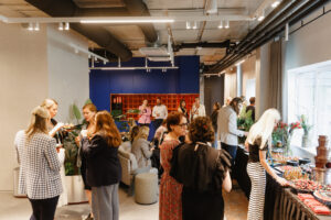 Social gathering with people enjoying food in modern space.