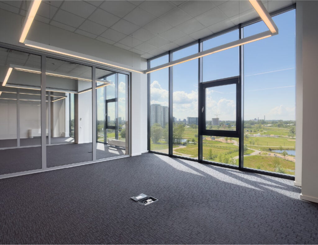 Empty office with large windows and city view.