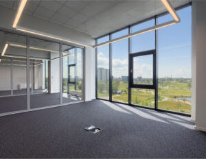 Empty office with large windows and city view.
