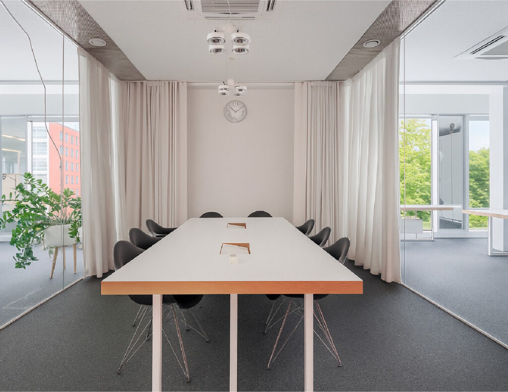 Modern conference room with long table and chairs.
