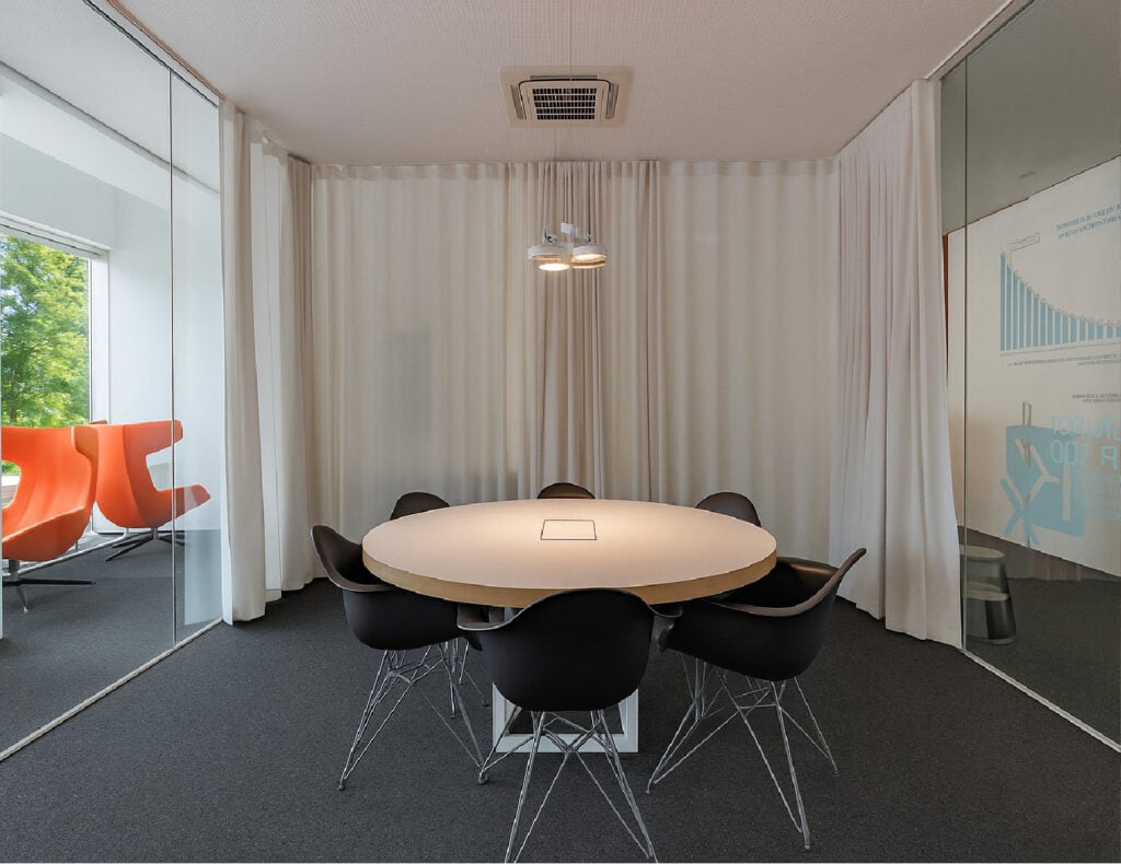 Modern conference room with round table and chairs.