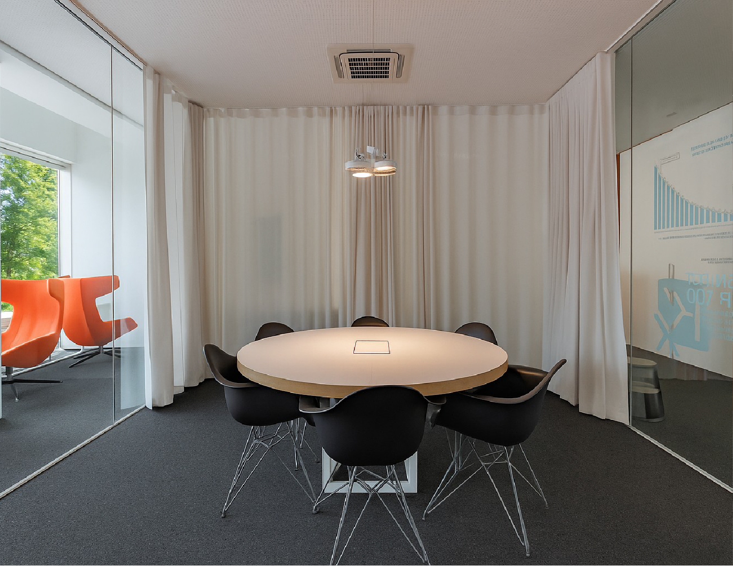 Modern conference room with round table and chairs.
