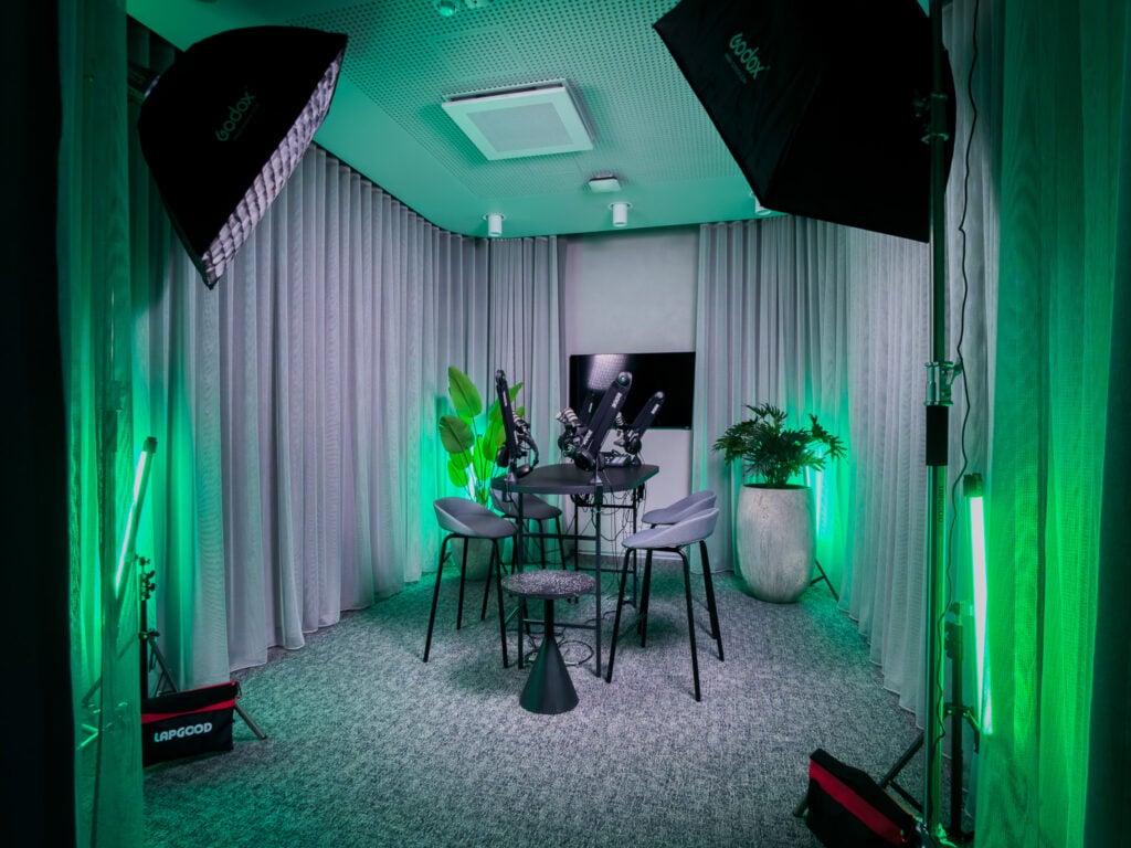 Modern podcast studio with lighting and microphones setup.