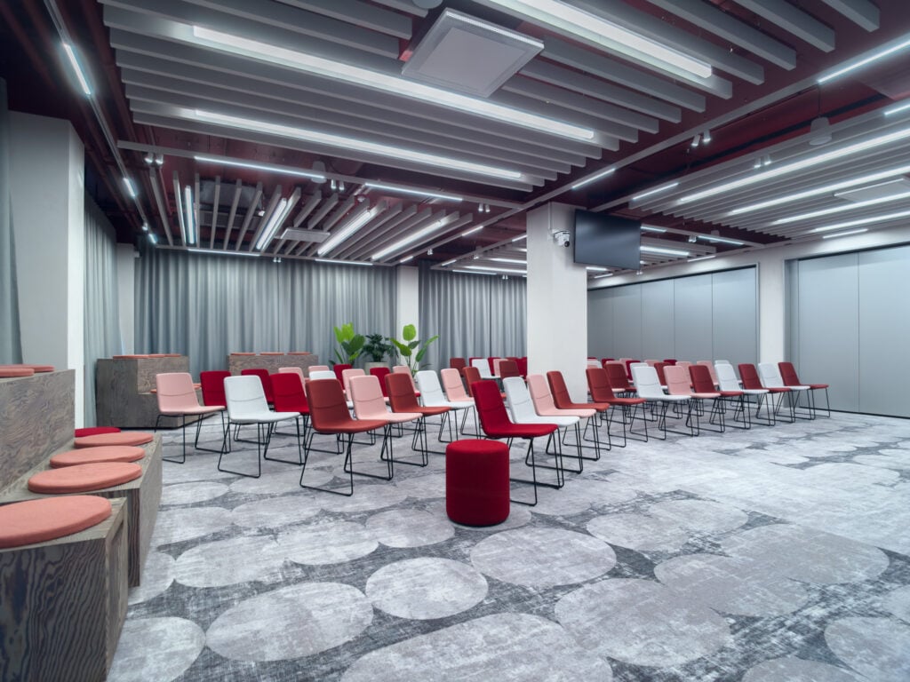 Modern conference room with red chairs and gray curtains