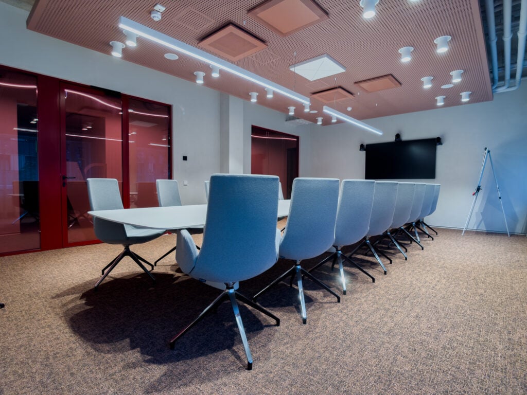Modern conference room with large table and chairs.