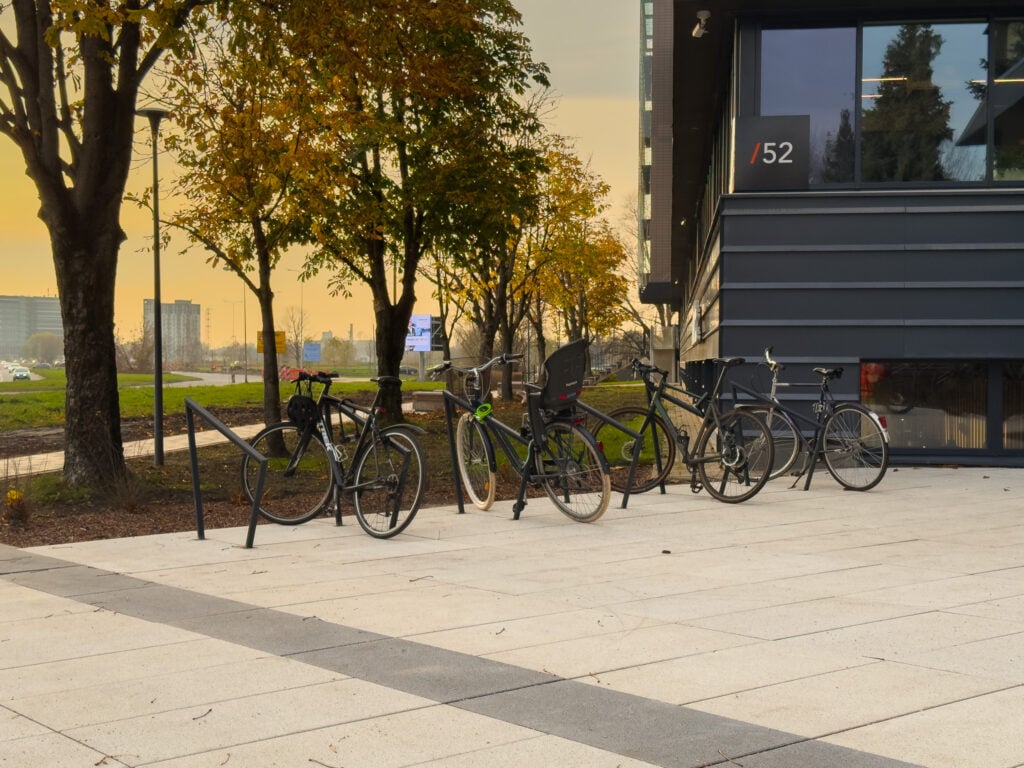 Bicycles parked outside modern building at sunset.