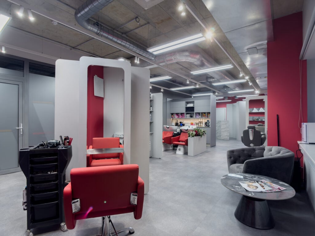 Modern hair salon with red and gray decor.